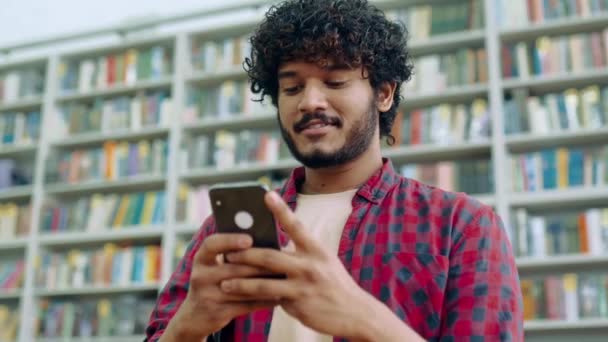 Happy Indian Arabian Millennial Guy Freelancer Student Using His Smartphone — Vídeo de Stock
