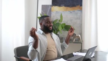 Satisfied peaceful calm African American stylish man, freelancer, designer, company ceo, taking a break, resting from online work or study in a laptop, meditating with closed eyes, relaxing, smiling