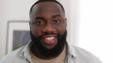 Close-up photo of positive confident handsome successful african american young man in stylish casual wear, male freelancer, executive, product manager, looking at the camera, smiling friendly