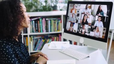 Video meeting. Successful African American woman, company worker, sits at a work desk in front of a computer, takes an online brainstorm, business conversation with multiracial group of people