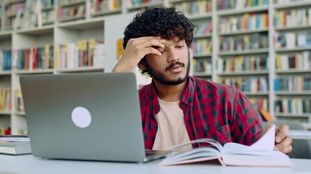 Sad Arabian Indian Male Student Tired Studying Sits Desk Library — Stockvideo