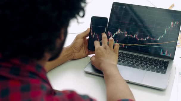 Smart Man Investor Crypto Trader Using Laptop Cellphone Analyzes Charts — Stockvideo