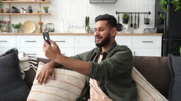 Positive Mixed Race Young Stylish Man Sitting Sofa Living Room — Stock videók