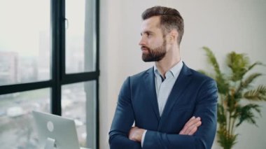 Yakışıklı, kendine güvenen, zarif, beyaz sakallı, takım elbiseli, üst düzey yönetici, şirketin CEO 'su, finans müdürü, kollarını kavuşturmuş, kameraya bakıyor, gülümsüyor.