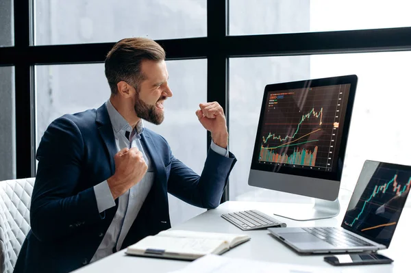 Mutlu, başarılı beyaz erkek borsa yatırımcısı, borsacı, çalışma masasına oturur, bilgisayara bakar, hisse senetlerinin büyümesinden memnun olur, büyük kârlar, kripto para biriminin yükselişi, el kol hareketi yapar
