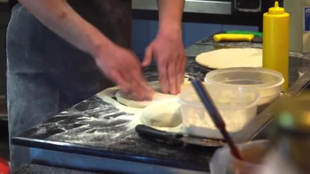 Koki membentuk adonan pizza, menyebarkannya pada lembaran pemanggang logam — Stok Video