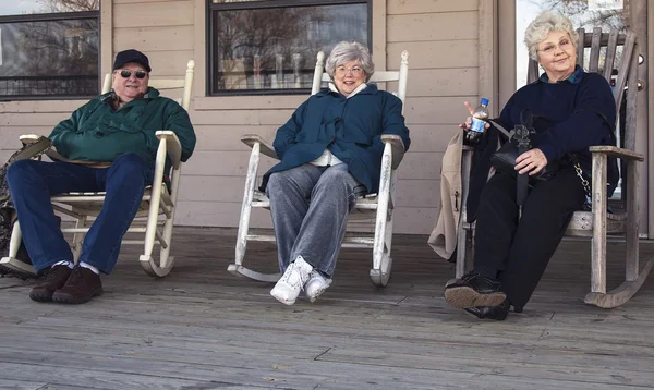 Tři senioři těší houpat na verandě — Stock fotografie