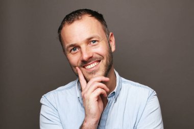 Güzel, mutlu bir adamın portresi. Renkli bir arka planın önünde.