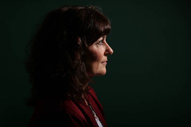 Güzel, mutlu bir kadının portresi. Renkli bir arka planın önünde.