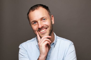 Güzel, mutlu bir adamın portresi. Renkli bir arka planın önünde.
