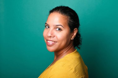  Güzel, mutlu bir kadının portresi. Renkli bir arka planın önünde.