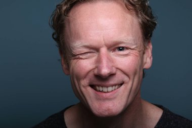 Renkli bir arkaplan önünde güzel, mutlu bir adamın portresi. Yüksek kalite fotoğraf