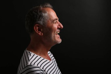 Güzel, mutlu bir adamın portresi. Renkli bir arka planın önünde.