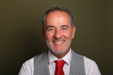 Güzel, mutlu bir adamın portresi. Renkli bir arka planın önünde.