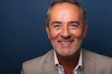 Güzel, mutlu bir adamın portresi. Renkli bir arka planın önünde.