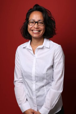 Güzel, mutlu bir kadının portresi. Renkli bir arka planın önünde.