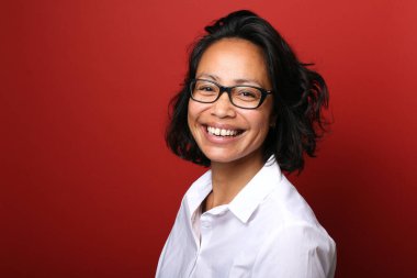 Güzel, mutlu bir kadının portresi. Renkli bir arka planın önünde.