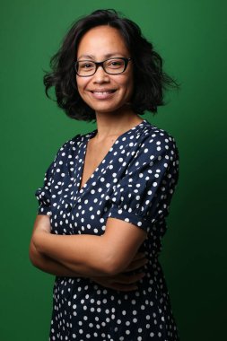 Güzel, mutlu bir kadının portresi. Renkli bir arka planın önünde.