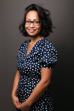 Güzel, mutlu bir kadının portresi. Renkli bir arka planın önünde.