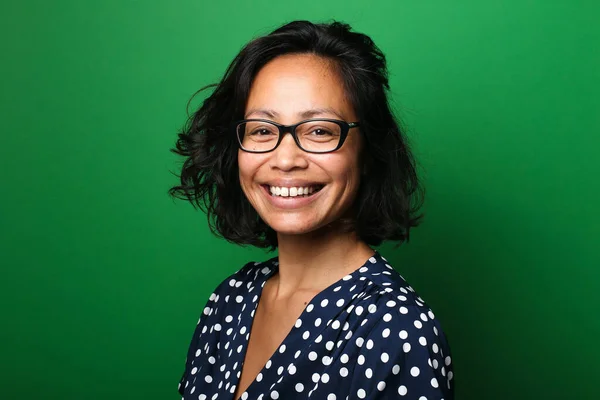 Güzel, mutlu bir kadının portresi. Renkli bir arka planın önünde.