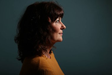 Güzel, mutlu bir kadının portresi. Renkli bir arka planın önünde.