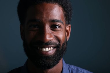 Güzel, mutlu bir adamın portresi. Renkli bir arka planın önünde.