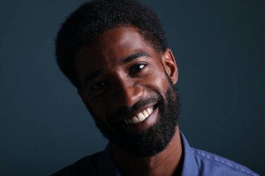 Güzel, mutlu bir adamın portresi. Renkli bir arka planın önünde.