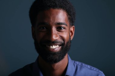 Güzel, mutlu bir adamın portresi. Renkli bir arka planın önünde.