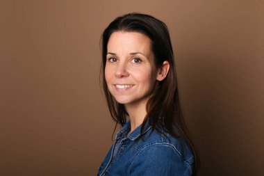 Güzel, mutlu bir kadının portresi. Renkli bir arka planın önünde.