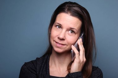 Güzel, mutlu bir kadının portresi. Renkli bir arka planın önünde.