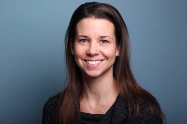 Güzel, mutlu bir kadının portresi. Renkli bir arka planın önünde.