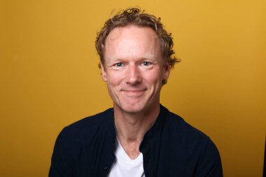 Güzel, mutlu bir adamın portresi. Renkli bir arka planın önünde.