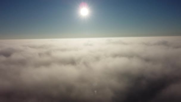 Güneş ufuk çizgisine kadar sonsuz bulut denizinin üzerinde yükseliyor. Gökyüzünde 4K İHA — Stok video
