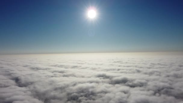 Güneş ufuk çizgisine kadar sonsuz bulut denizinin üzerinde yükseliyor. Gökyüzünde 4K İHA — Stok video