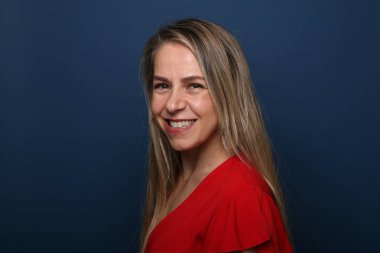 Güzel, mutlu bir kadının portresi. Renkli bir arka planın önünde.