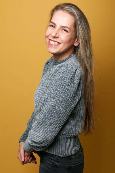 Porträtt av en vacker lycklig kvinna framför en färgad bakgrund — Stockfoto