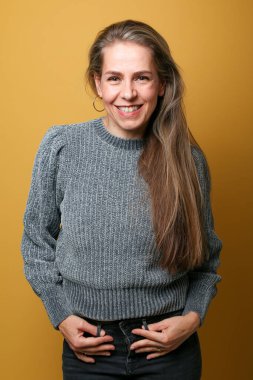 Güzel, mutlu bir kadının portresi. Renkli bir arka planın önünde.