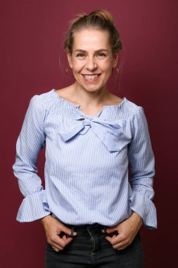 Güzel, mutlu bir kadının portresi. Renkli bir arka planın önünde.