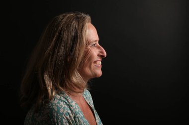 Güzel, mutlu bir kadının portresi. Renkli bir arka planın önünde.