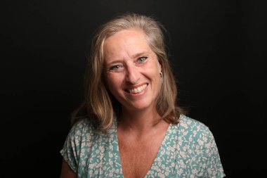 Güzel, mutlu bir kadının portresi. Renkli bir arka planın önünde.