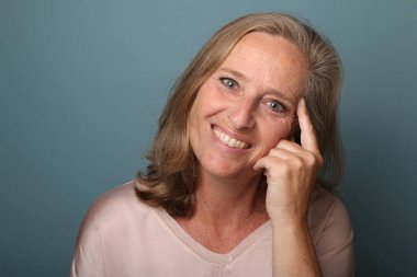 Güzel, mutlu bir kadının portresi. Renkli bir arka planın önünde.