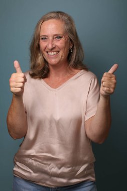 Güzel, mutlu bir kadının portresi. Renkli bir arka planın önünde.