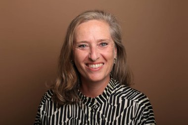 Güzel, mutlu bir kadının portresi. Renkli bir arka planın önünde.