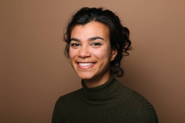 Güzel, mutlu bir kadının portresi. Renkli bir arka planın önünde.