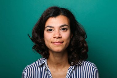 Güzel, mutlu bir kadının portresi. Renkli bir arka planın önünde.