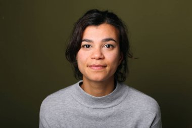 Güzel, mutlu bir kadının portresi. Renkli bir arka planın önünde.