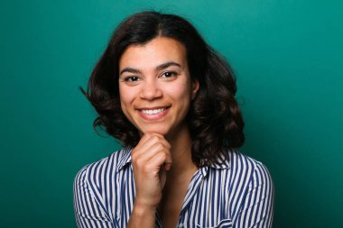 Güzel, mutlu bir kadının portresi. Renkli bir arka planın önünde.