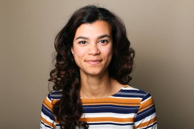 Güzel, mutlu bir kadının portresi. Renkli bir arka planın önünde.