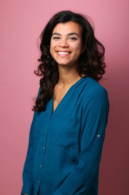 Güzel, mutlu bir kadının portresi. Renkli bir arka planın önünde.