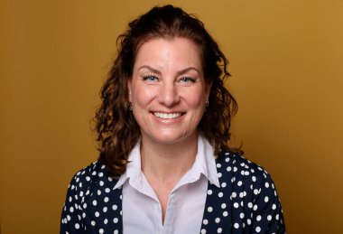 Güzel, mutlu bir kadının portresi. Renkli bir arka planın önünde.